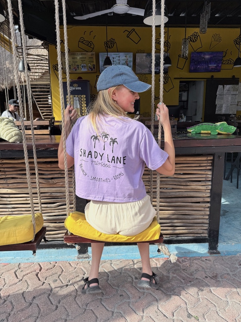 Wearing a purple Shade Lane t-shirt on a bae swing.